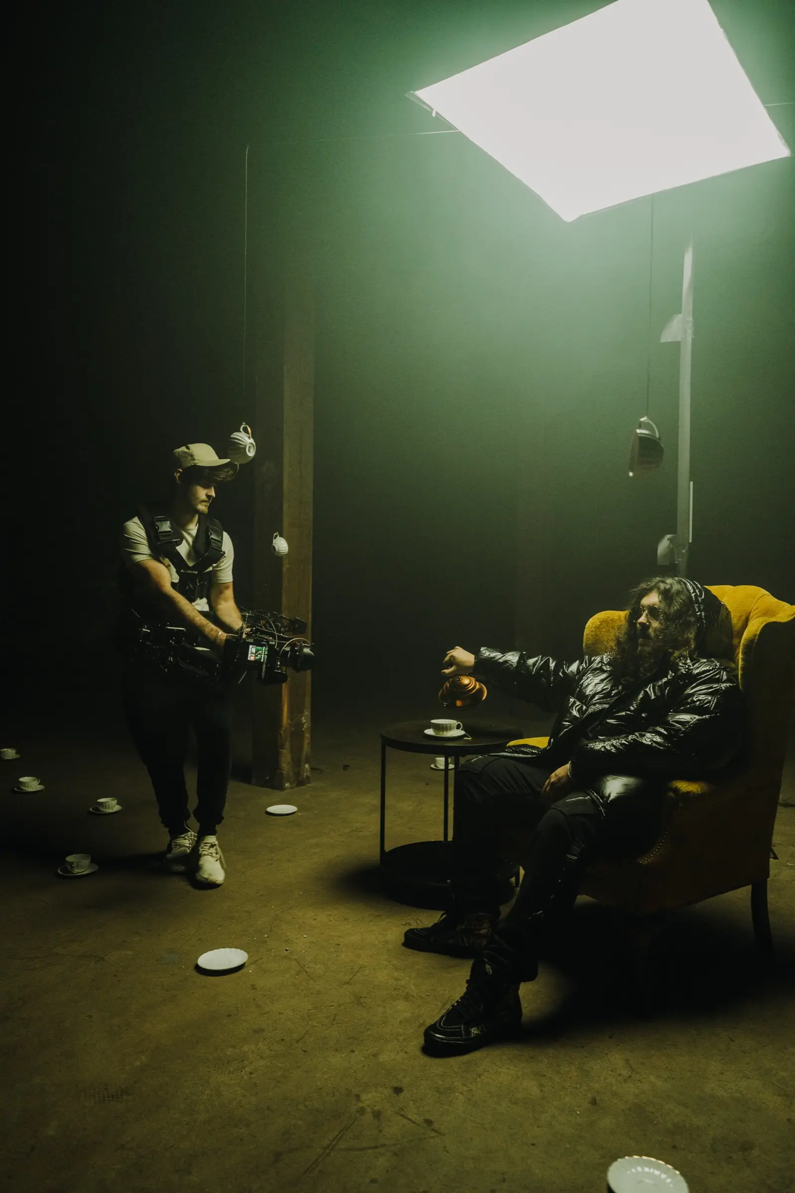 A gimbal operator in a hazy green room, an artist seated in a yellow armchair